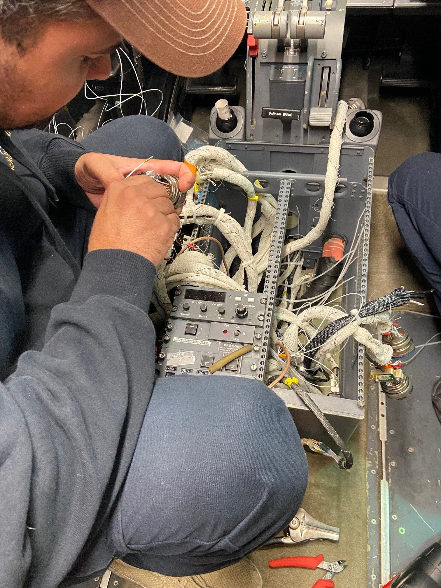 A man is kneeling down working on a piece of equipment.