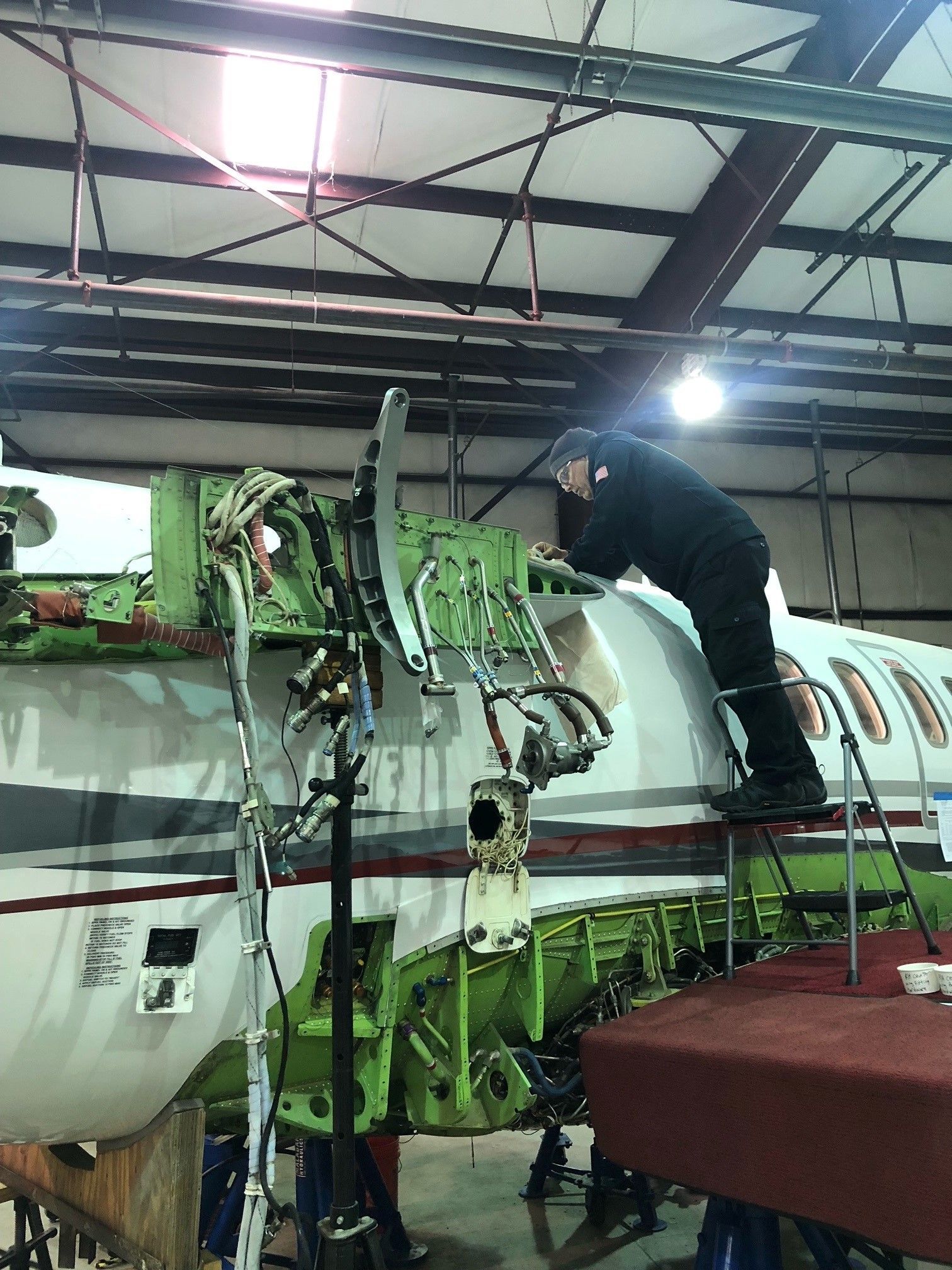 A man is working on a plane in a hangar