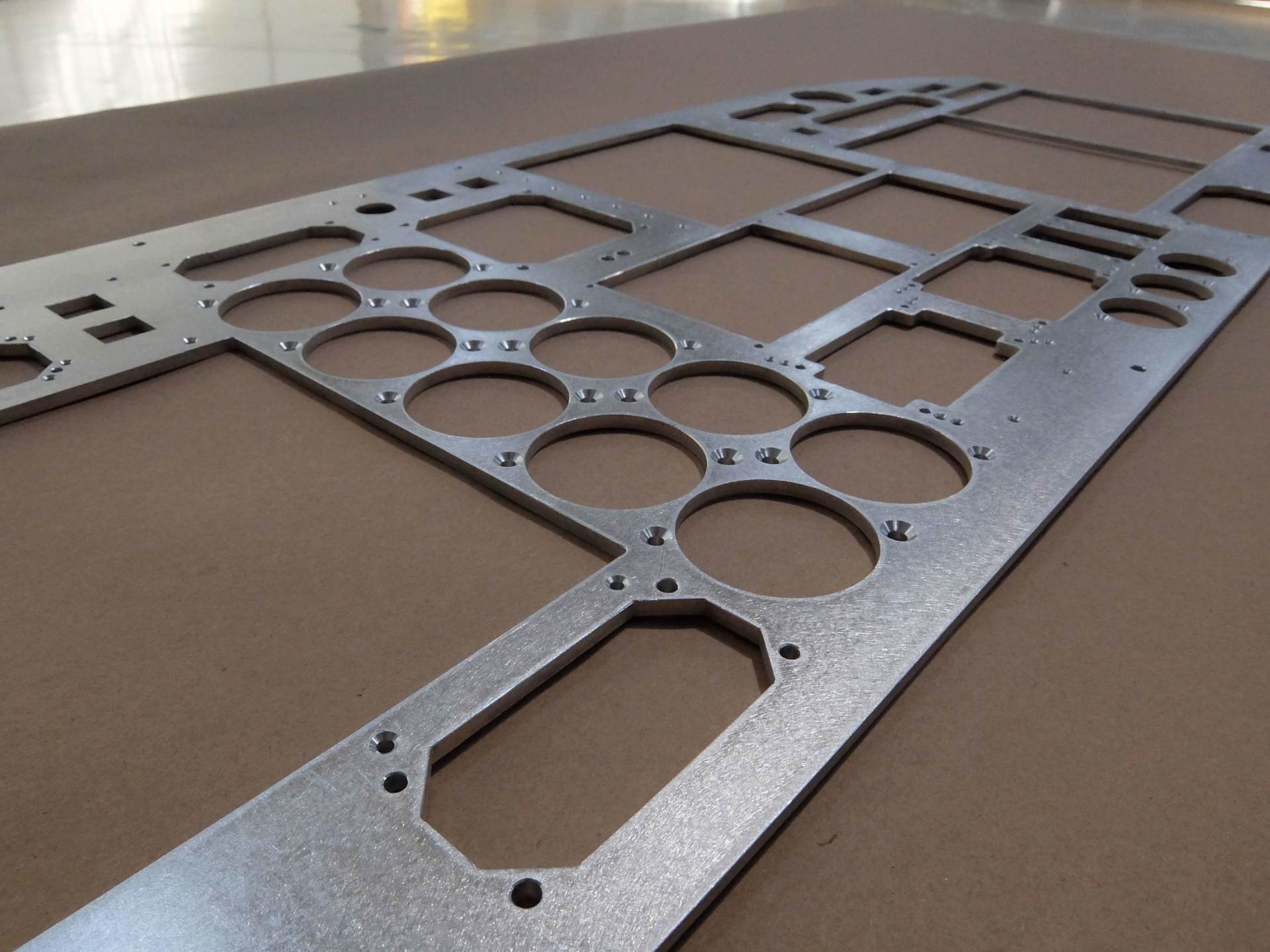 A piece of metal with holes in it is laying on a table