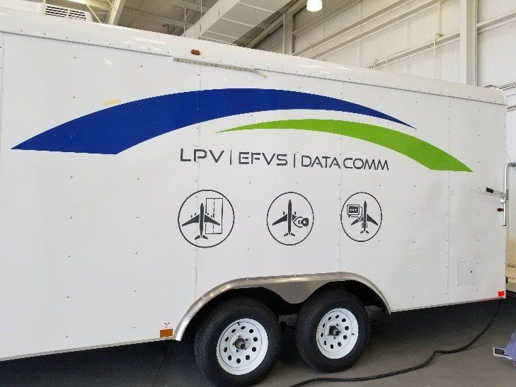 A white trailer with the words lpv efvs data comm on the side