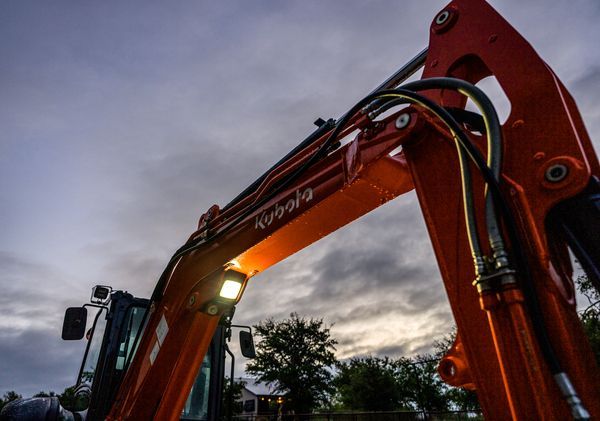 A man is sitting in the driver 's seat of a green tractor.