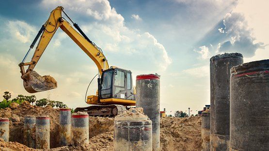 Excavator near pipes | Birch Run, MI | Duane Jones Excavating