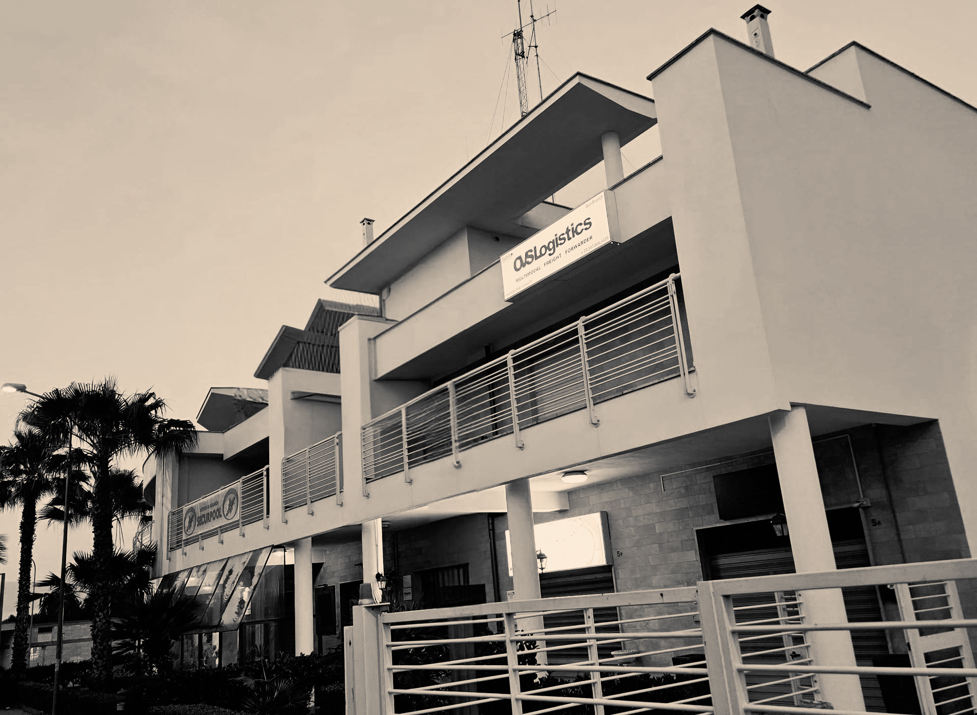 White building with balconies, sign for 