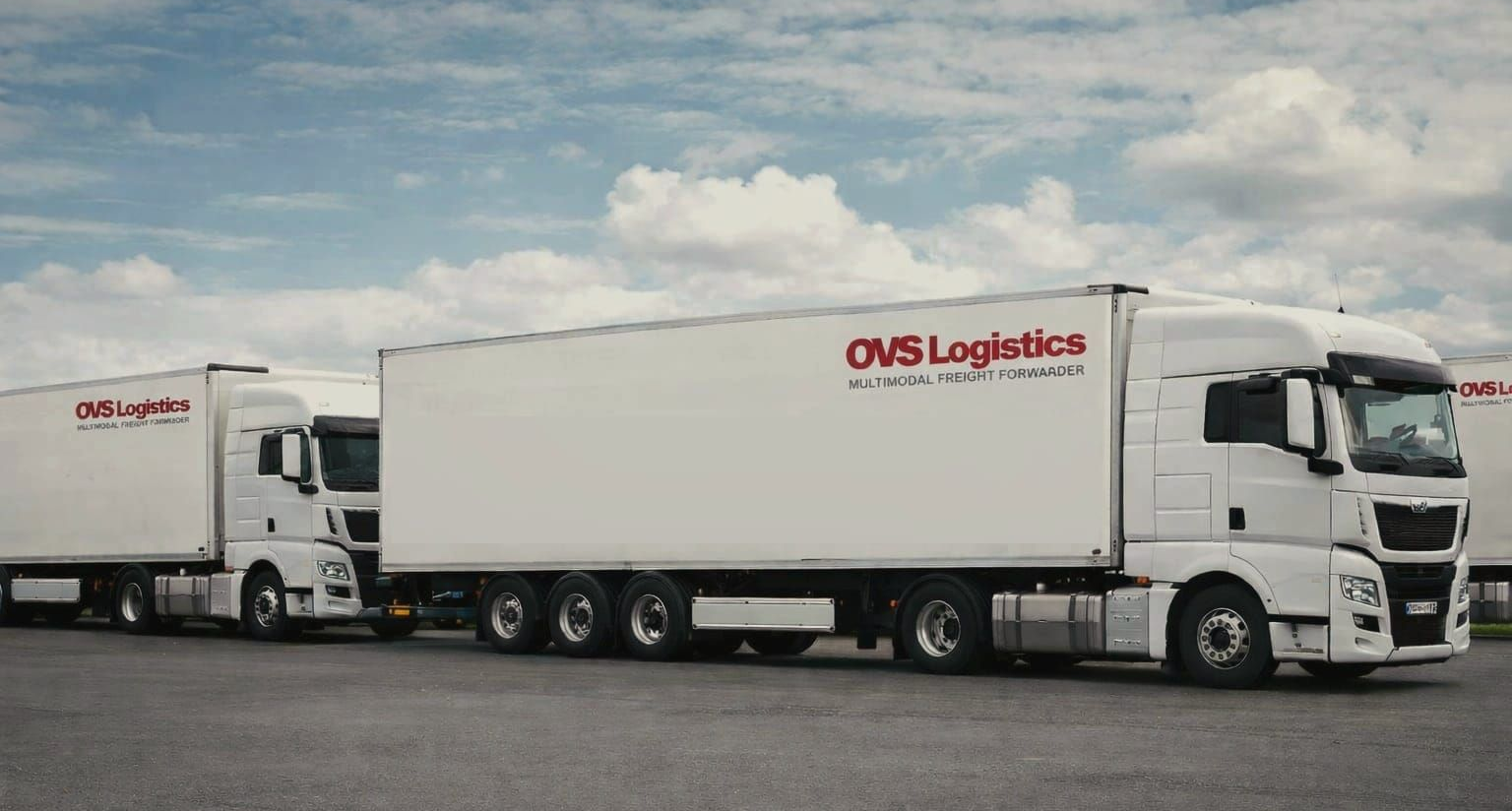 Aerial view of a truck parking lot with many white semi-trucks parked in rows.