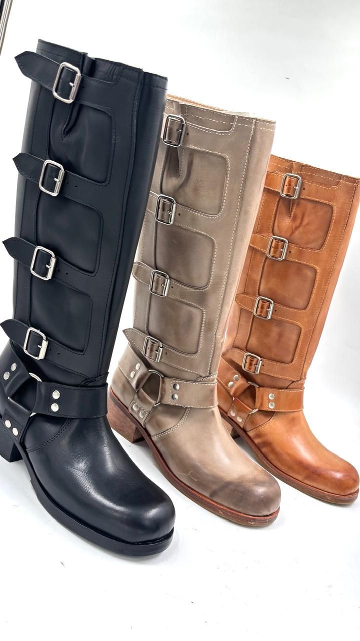 Tres pares de botas están colocadas una al lado de la otra sobre una superficie blanca.