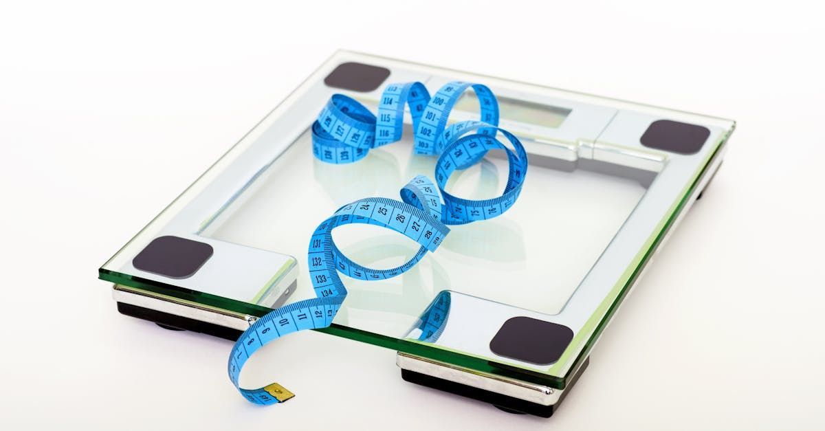 Blue measuring tape coiled on a bathroom scale with black corner pads