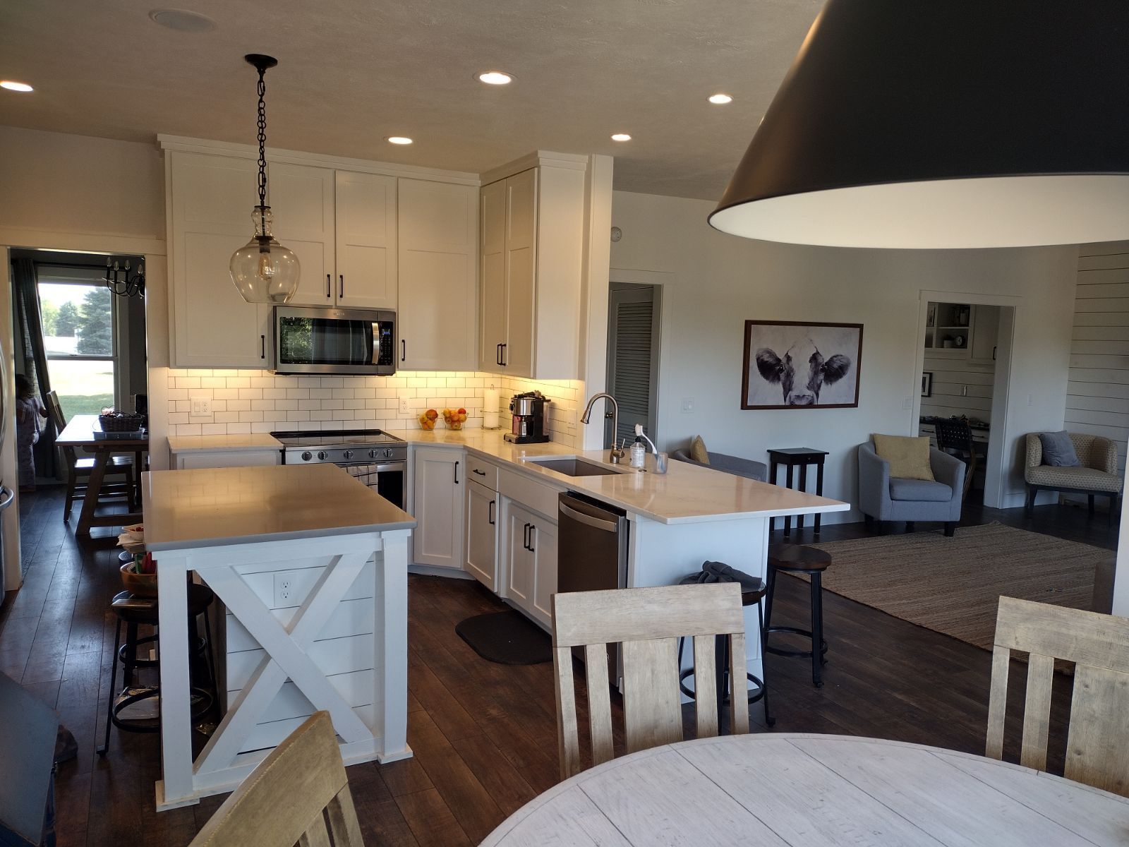 Kitchen with white cabinets, island, and dining area with a round table.