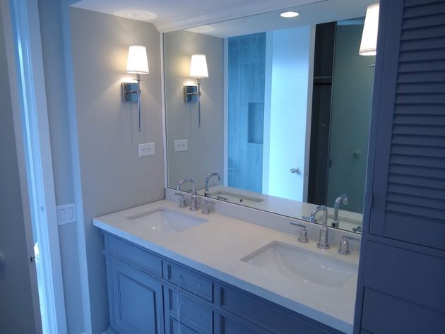 Bathroom with two illuminated rectangular mirrors above a double sink vanity.