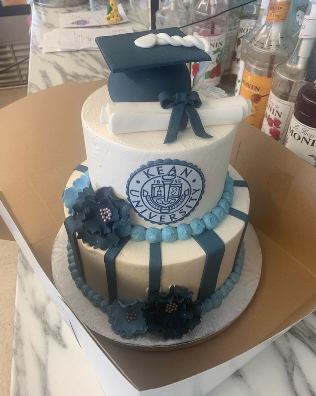 A cake with a graduation cap and diploma on top of it.