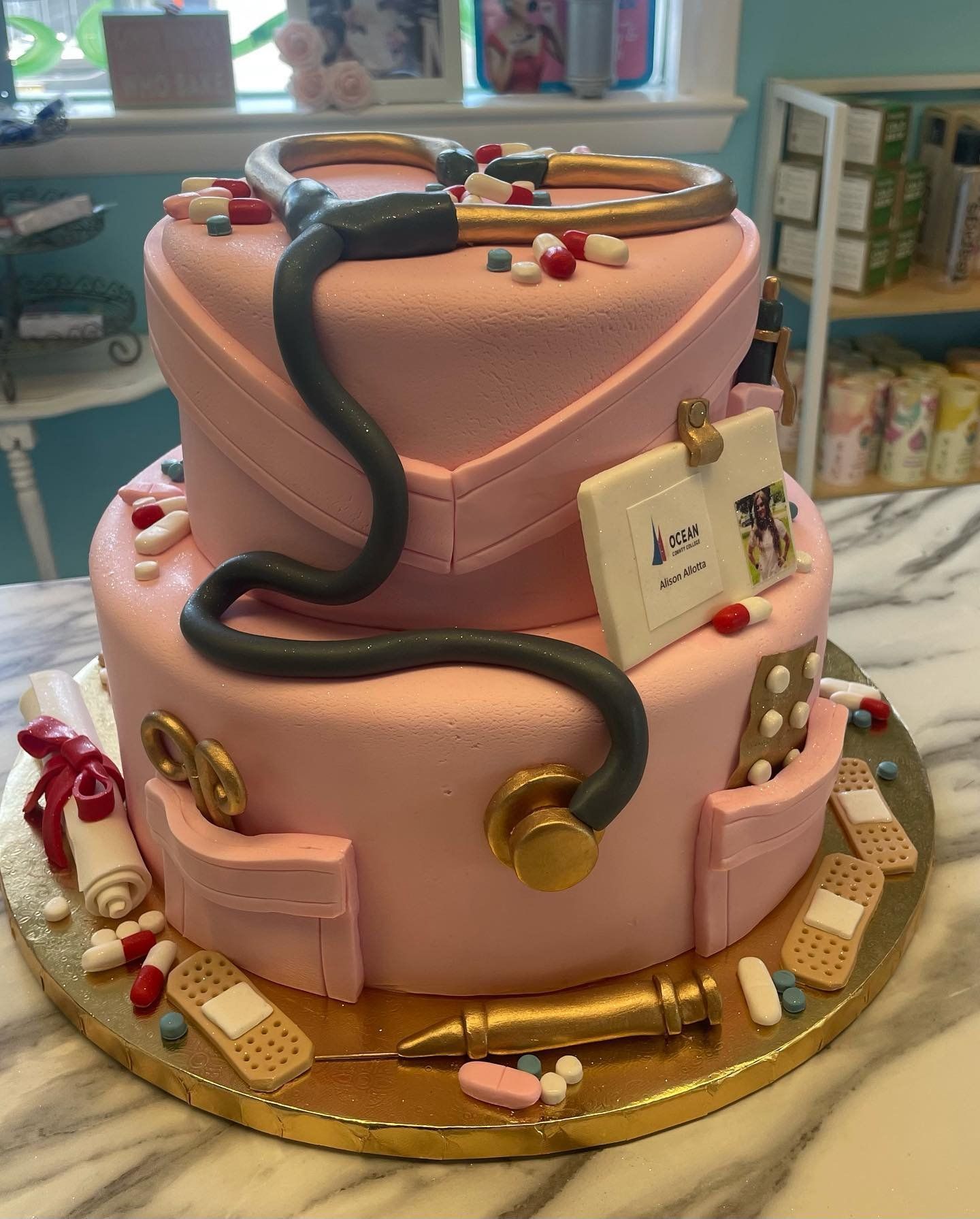 A pink cake with a stethoscope and pills on it