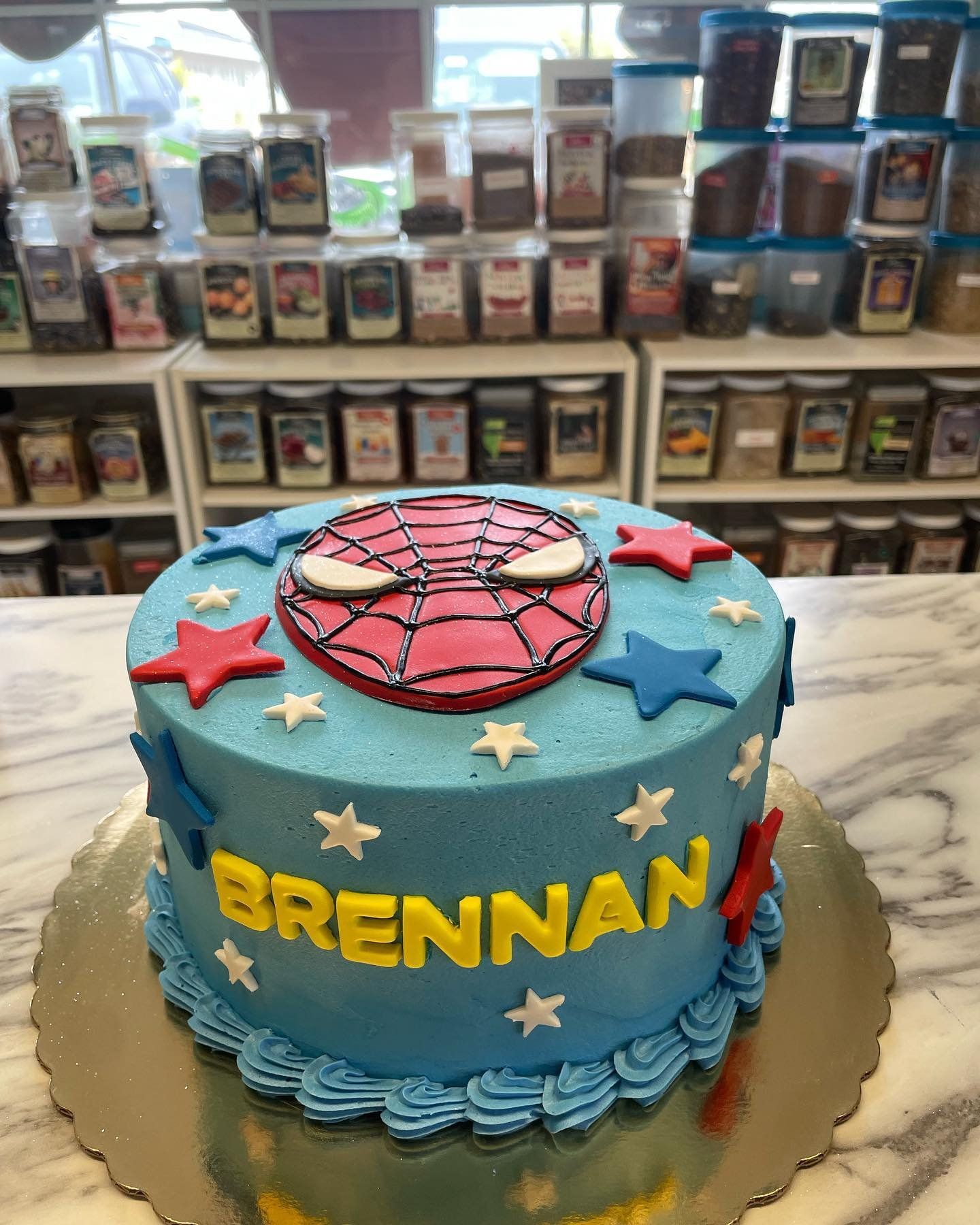 A spiderman cake with the name brennan on it