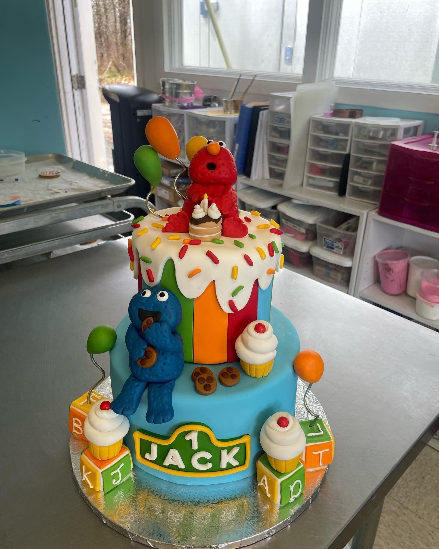 Elmo and cookie monster are on top of a birthday cake for jack