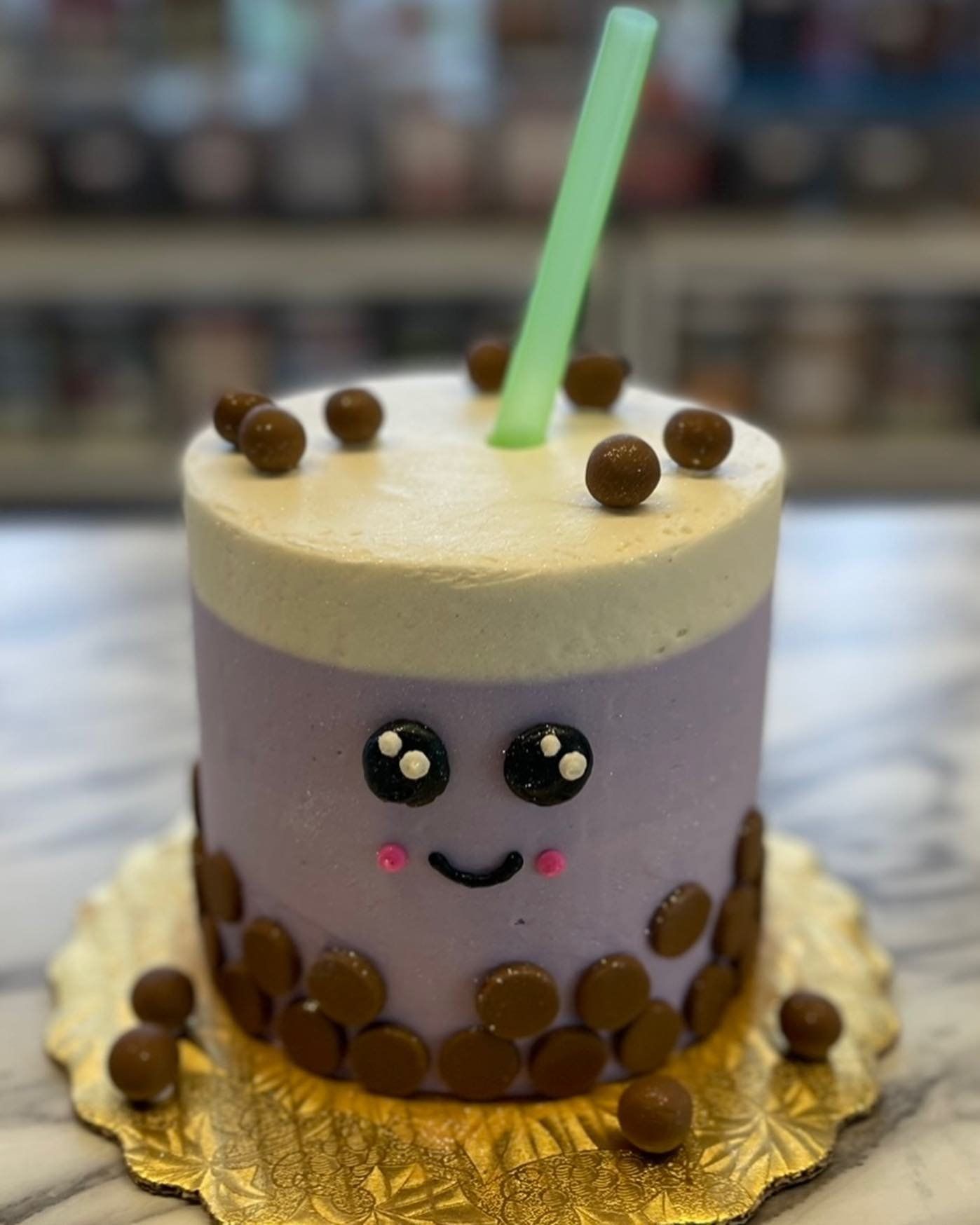 A purple cake with a green straw on top of it