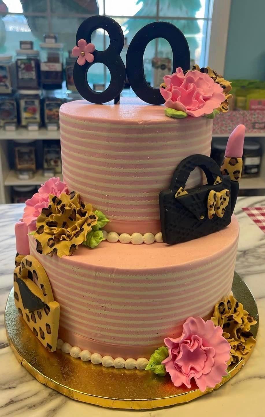 A pink cake with a black number 80 on top of it