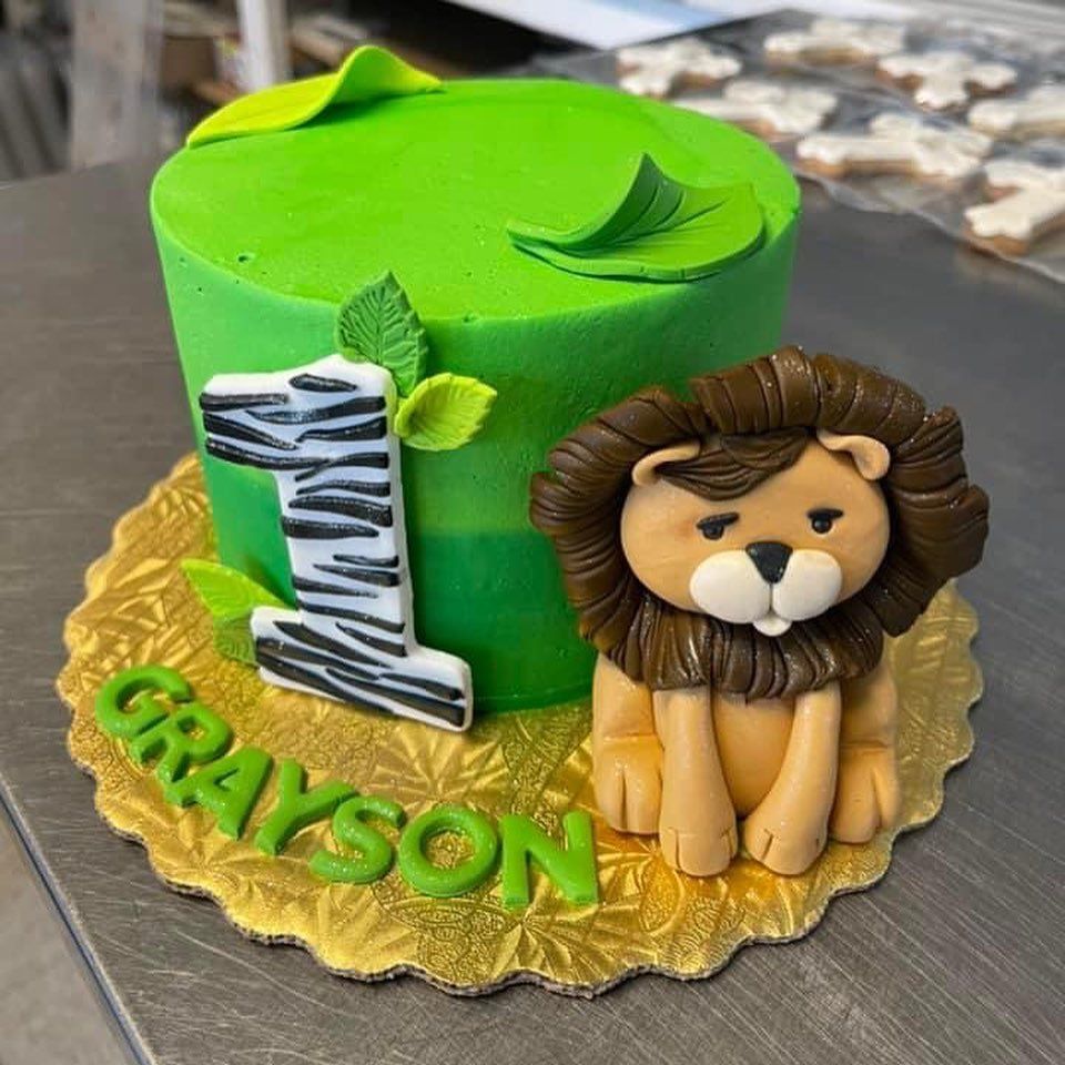 A green cake with a lion and the name grayson on it