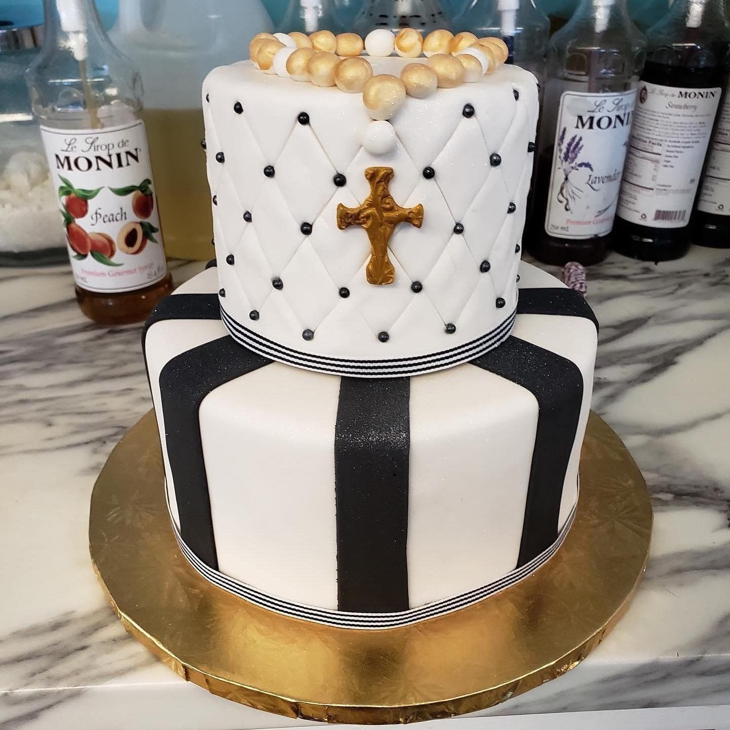 A black and white cake with a cross on top