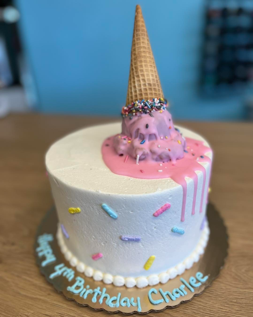 A birthday cake with an ice cream cone on top of it.