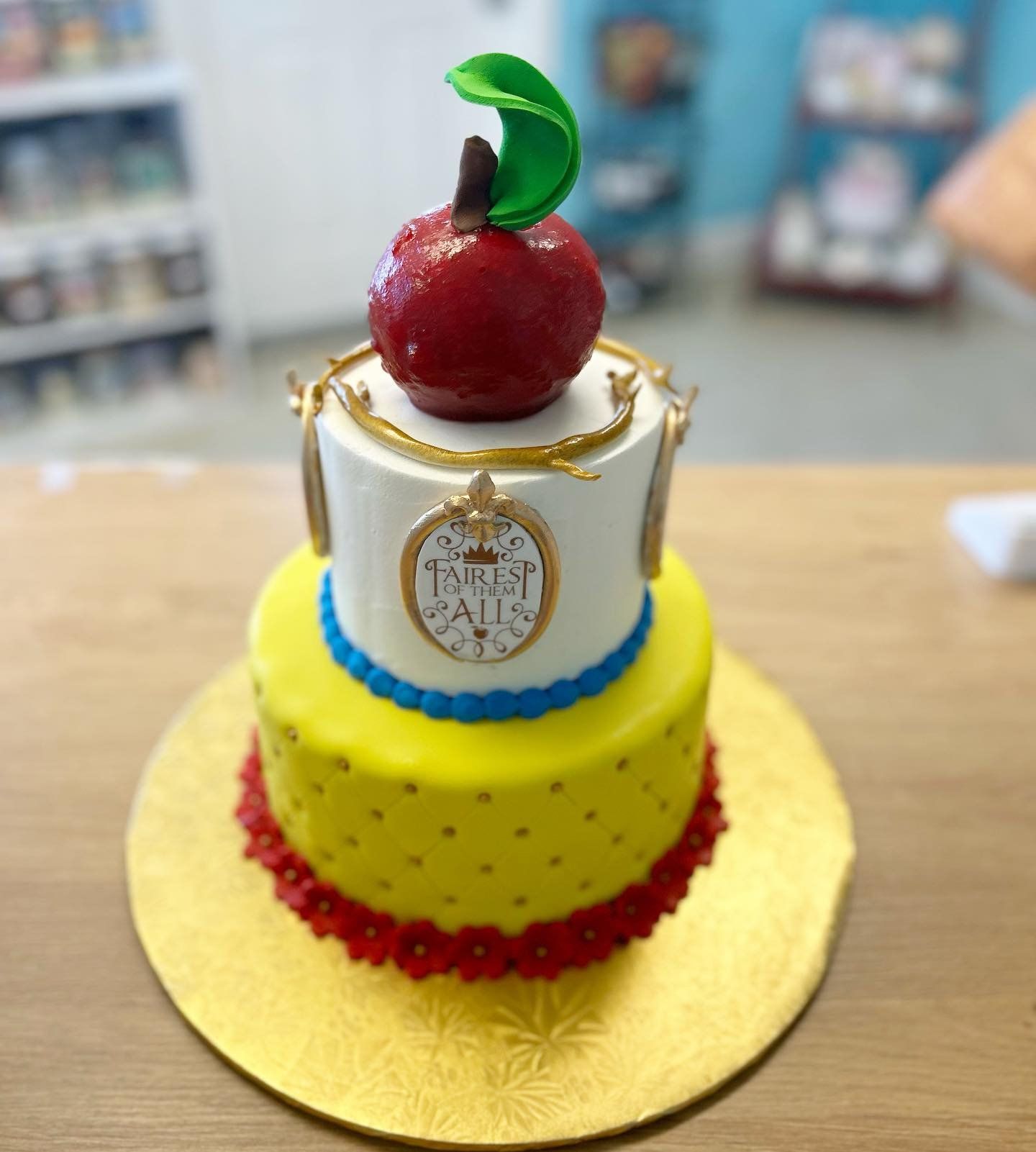 A yellow and white cake with an apple on top