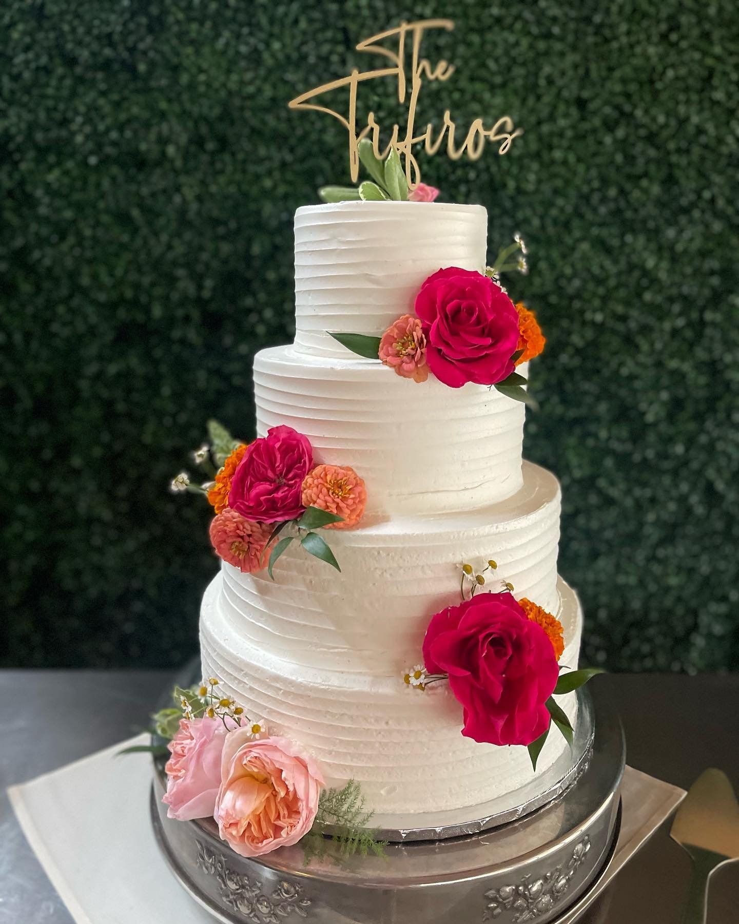 A wedding cake with flowers on it is sitting on a table.