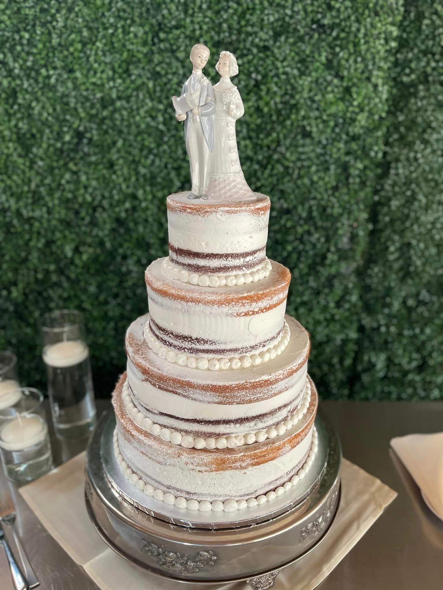 A wedding cake with a bride and groom figurine on top of it.