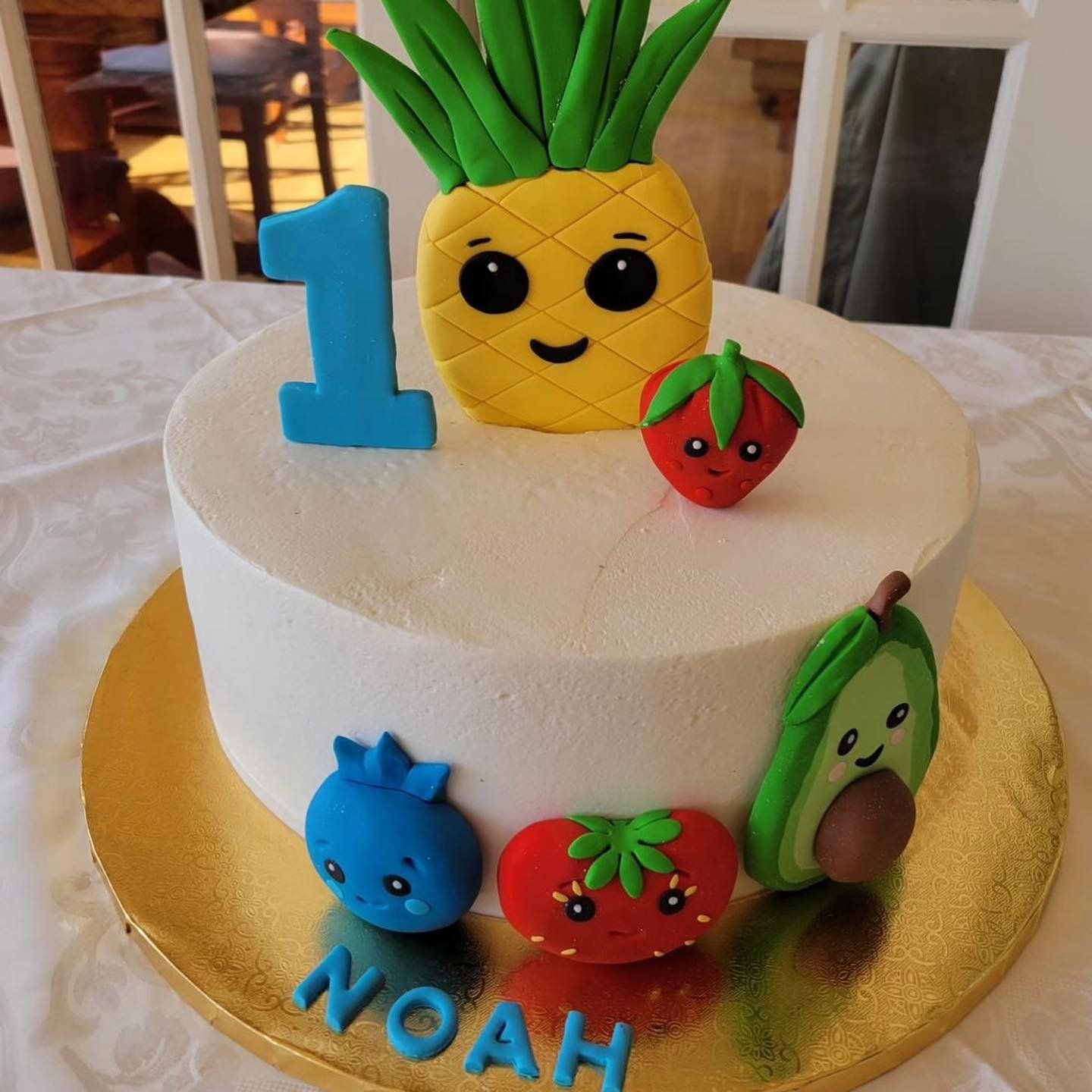 A first birthday cake for noah with a pineapple on top