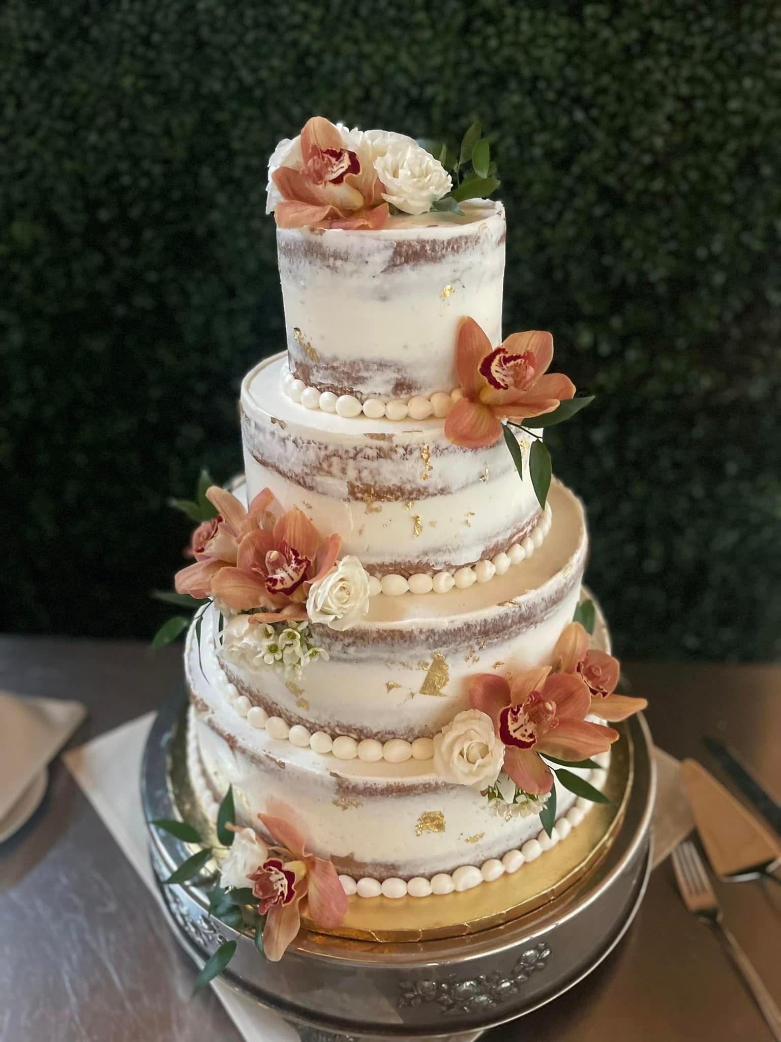 A wedding cake with flowers on it is sitting on a table.