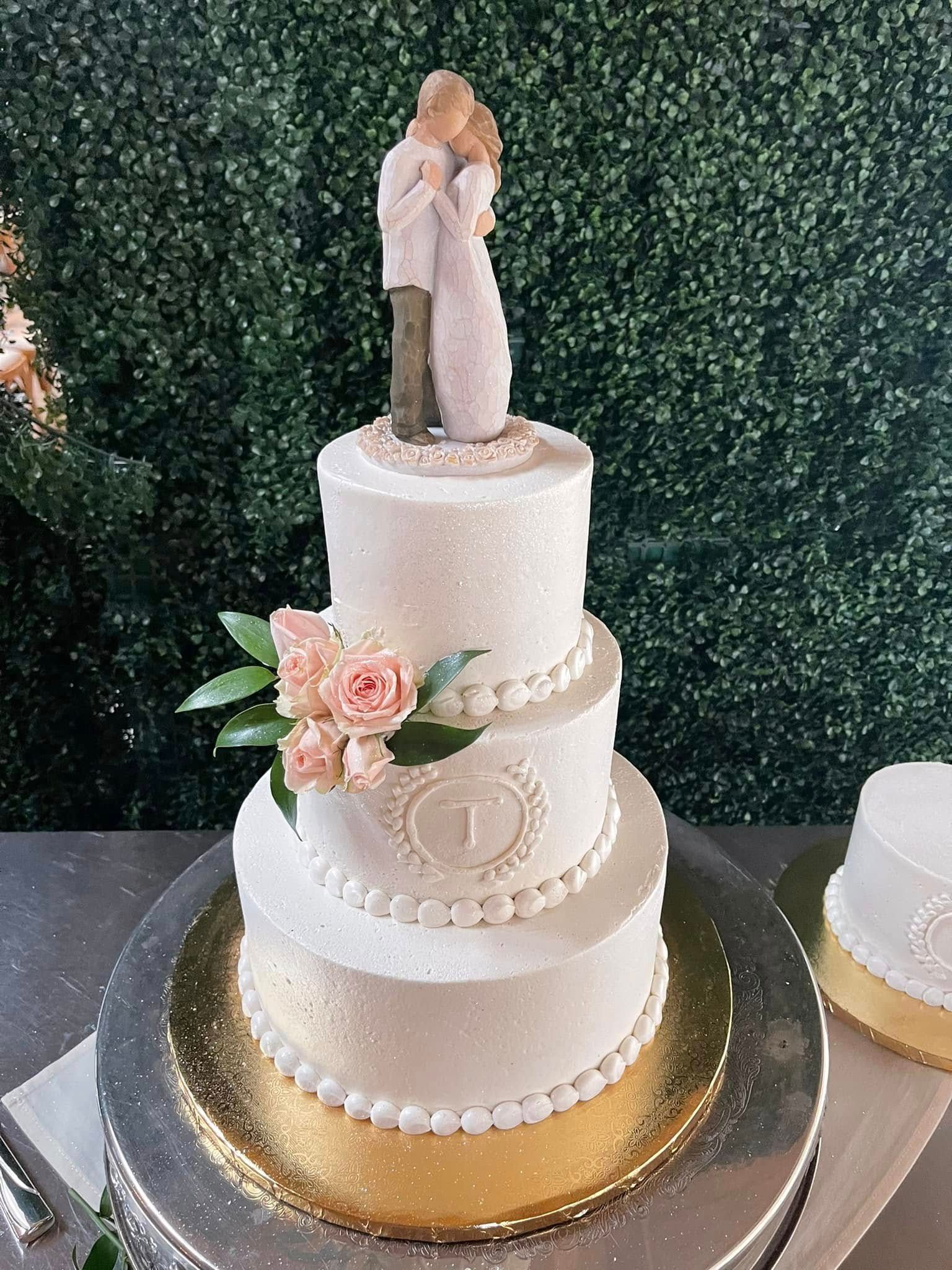 A wedding cake with a bride and groom figurine on top of it.