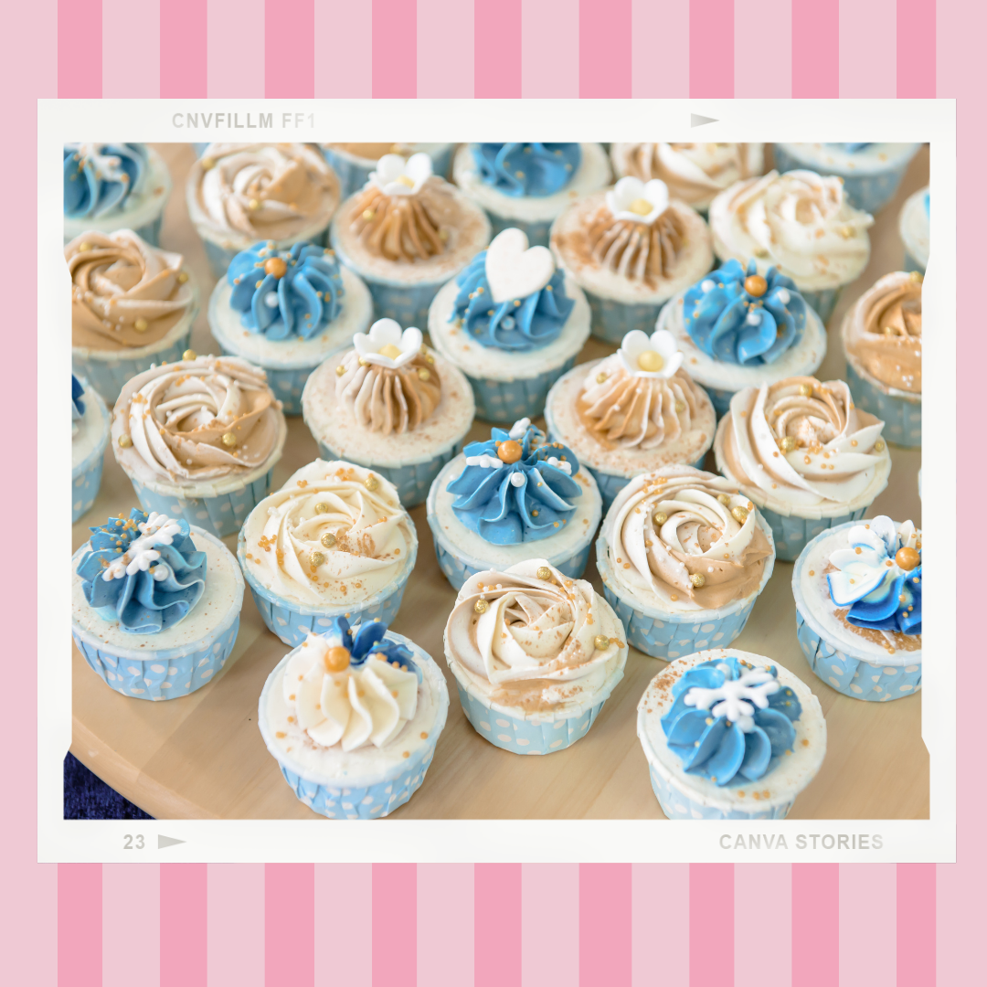 A bunch of cupcakes with blue and white frosting on a table.