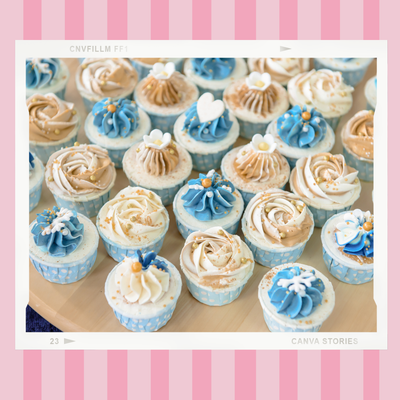 A bunch of cupcakes with blue and white frosting on a table.