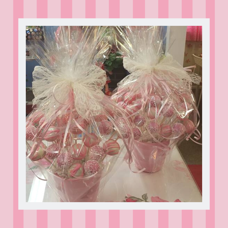 Two pink buckets filled with pink candy on a table