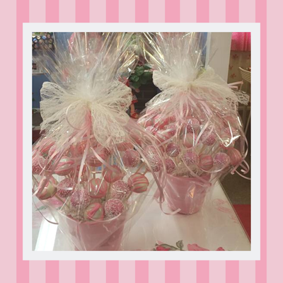 Two pink buckets filled with pink candy on a table