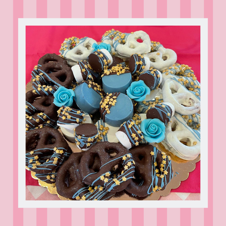 A plate of chocolate covered pretzels and cookies on a table