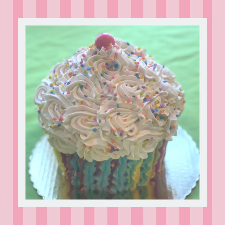 A giant cupcake with white frosting and sprinkles on top