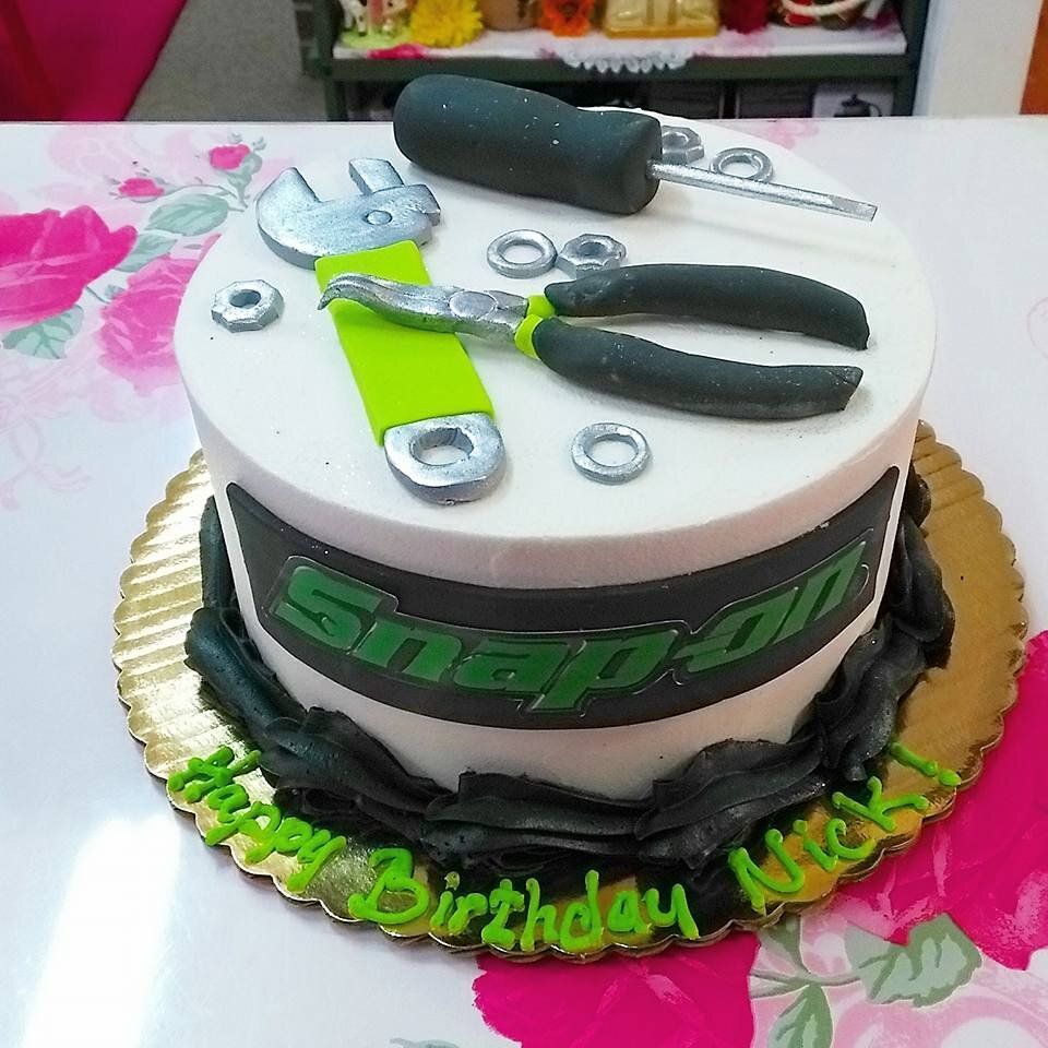 A snap on cake with a wrench and pliers on it