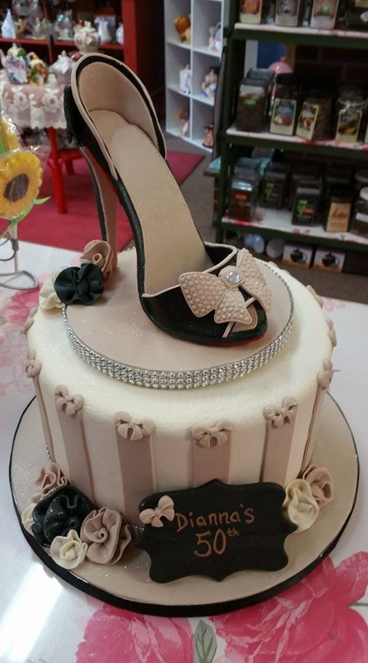 A cake with a shoe on top of it on a table.