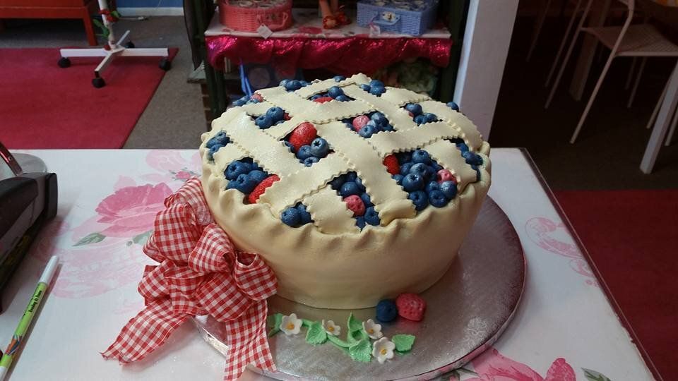 A cake that looks like a pie with blueberries on it