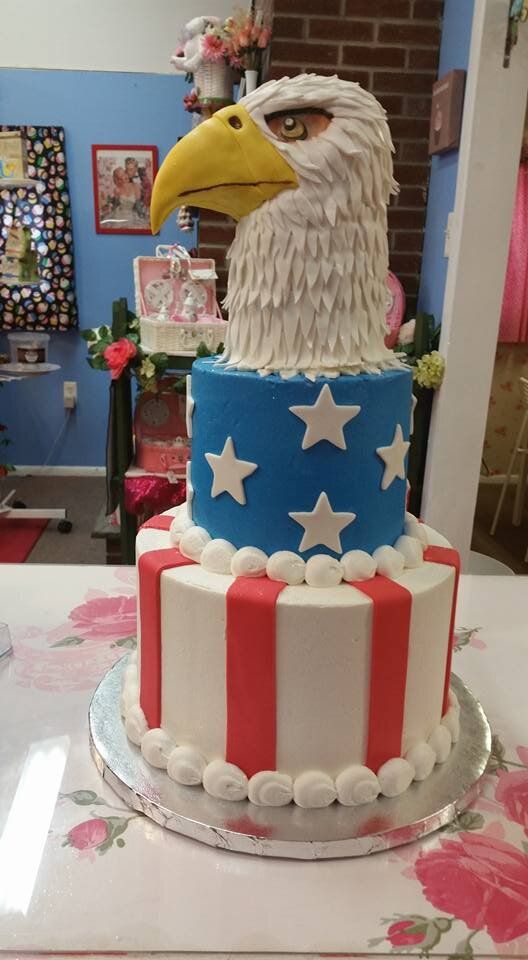A cake with an eagle on top of it is on a table.