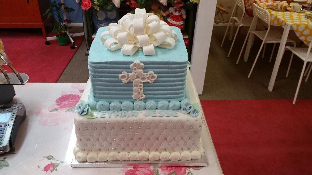 A blue and white cake with a cross on it is sitting on a table.