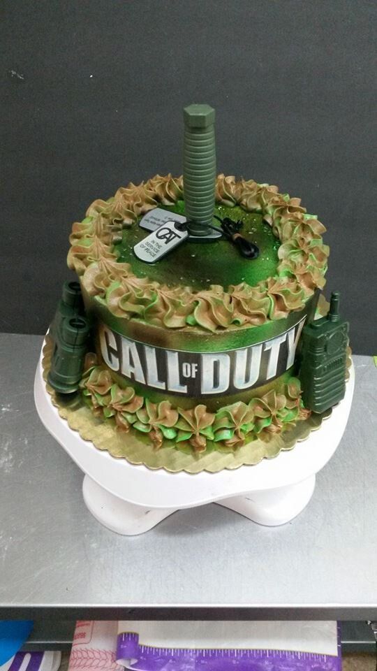 A call of duty cake is sitting on top of a white cake stand.