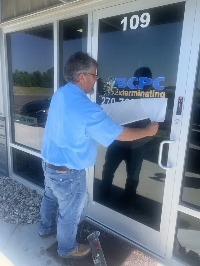 A Man Putting Sticker To The Door | Elizabethtown, KY | BCPC Exterminating