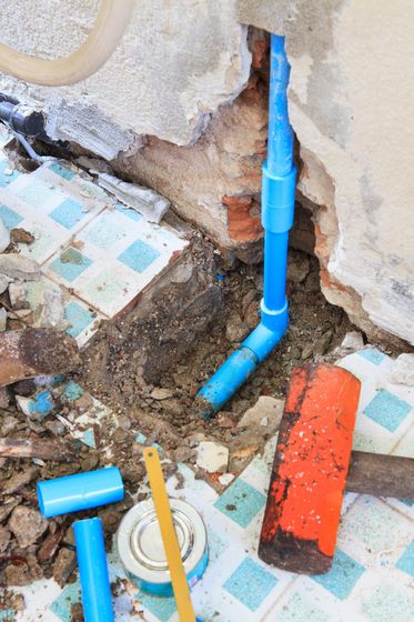 A pipe is being installed in a hole in a wall.