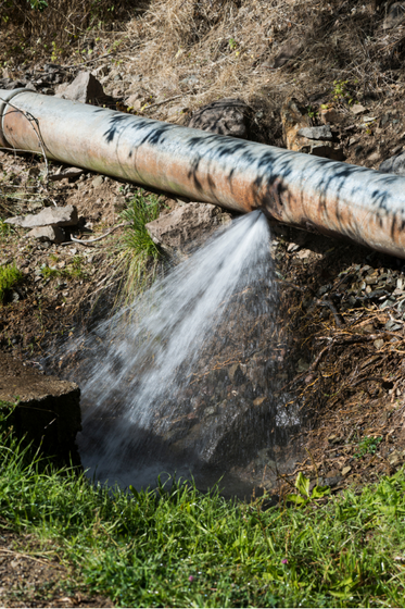 A water pipe is leaking water into a stream.