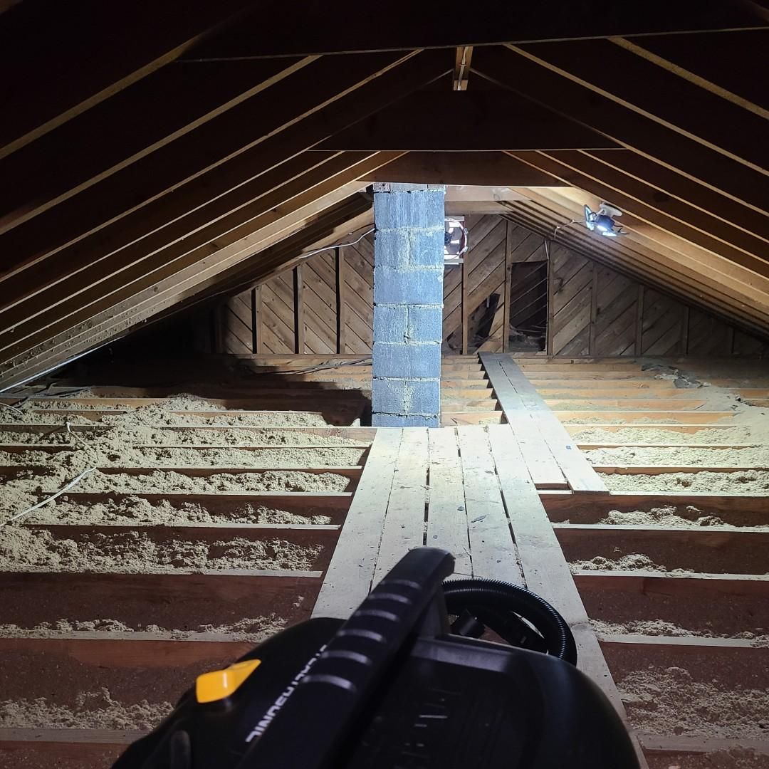 A vacuum cleaner is sitting in the attic of a building