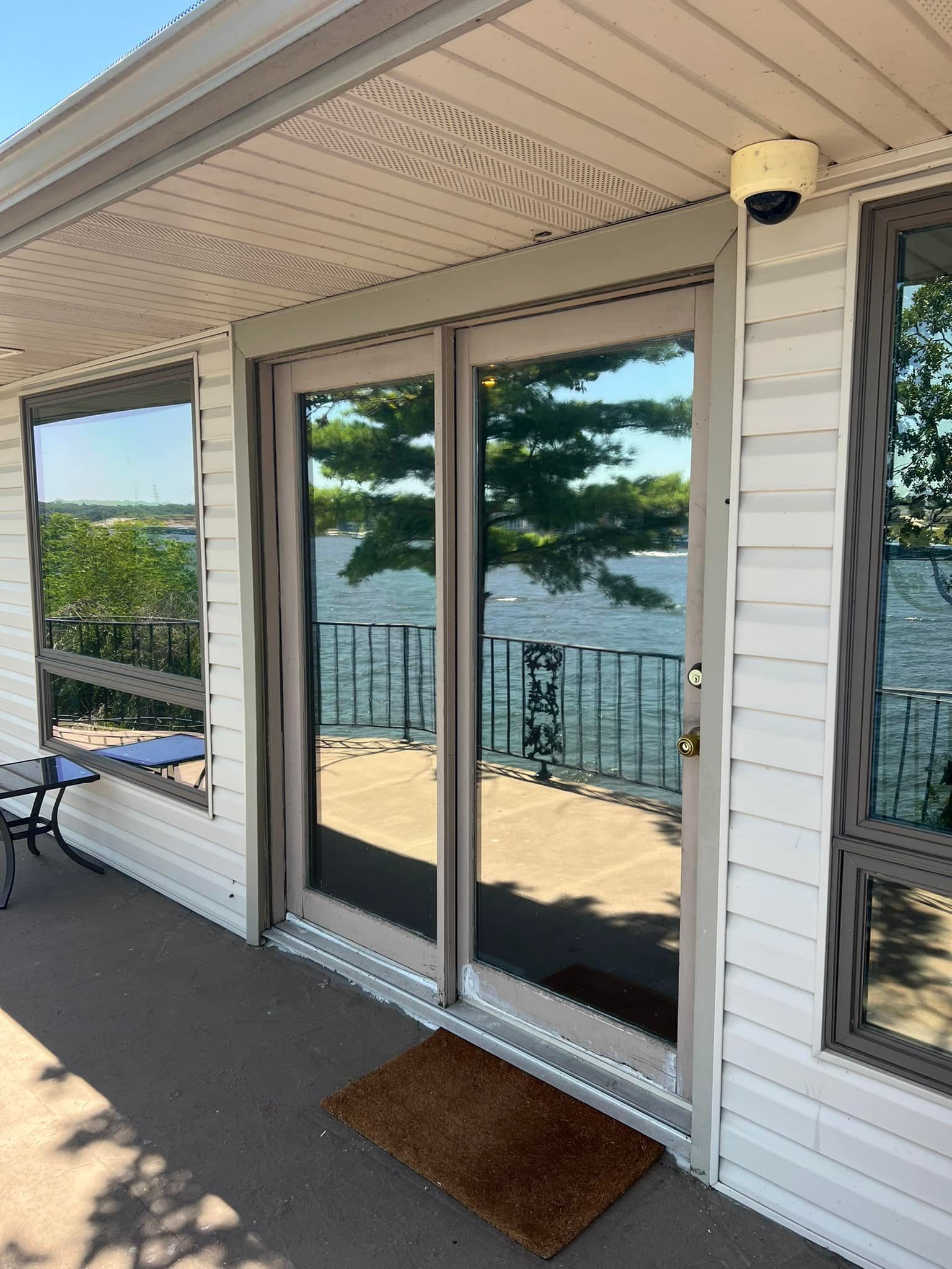 A White House with A Sliding Glass Door Leading to A Deck Overlooking a Lake | Wichita, KS | ICT Pros Window