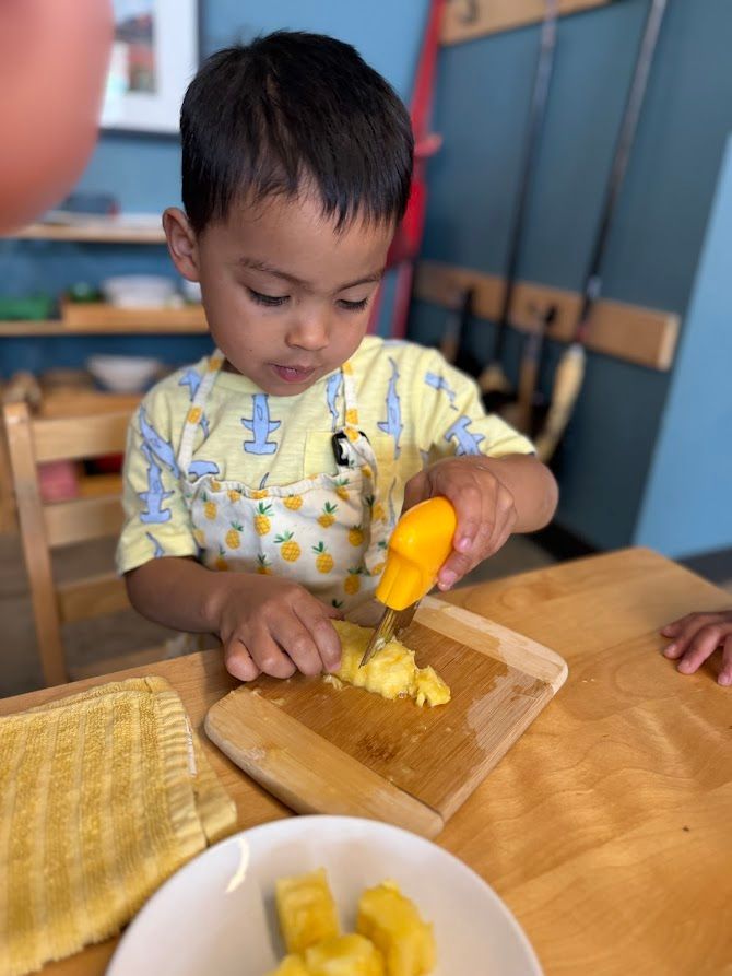 An IMA student prepares pineapple.