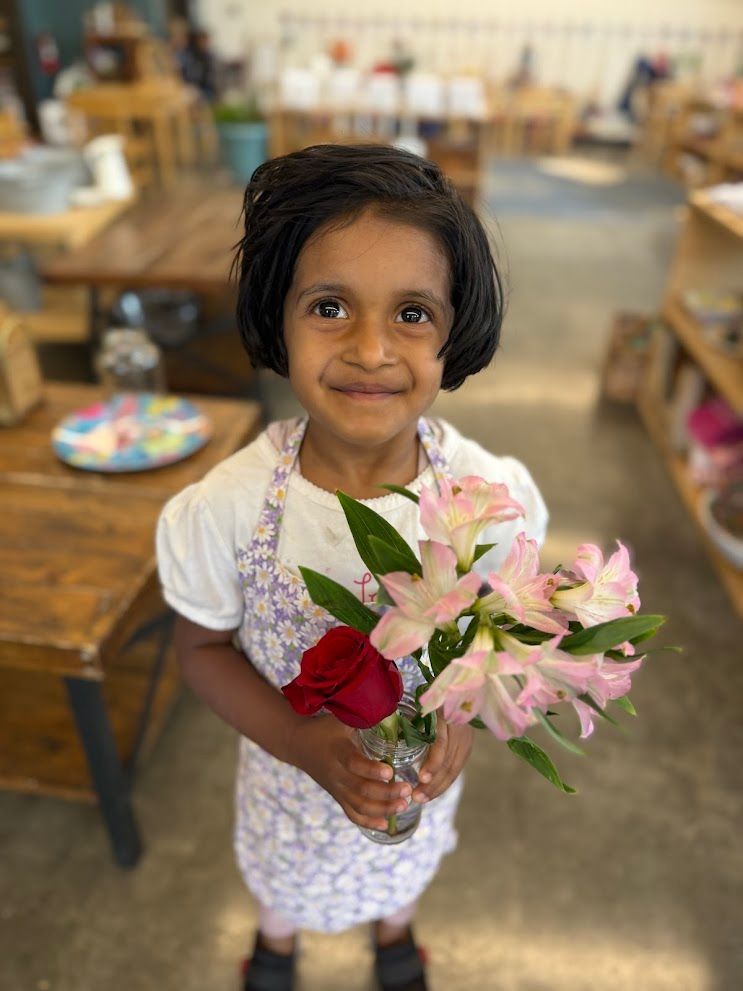 An IMA student proudly displays her flower bouqet!