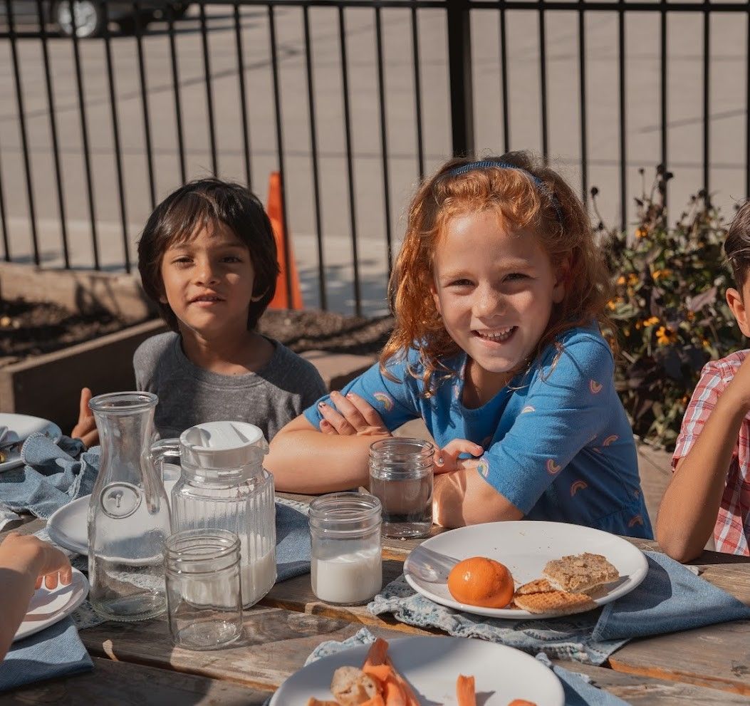 IMA primary children enjoy lunch outdoors in the Learning Gardens.