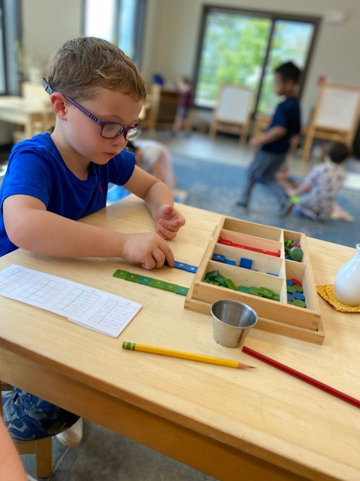 An IMA student works on math operations with the Stamp Game.