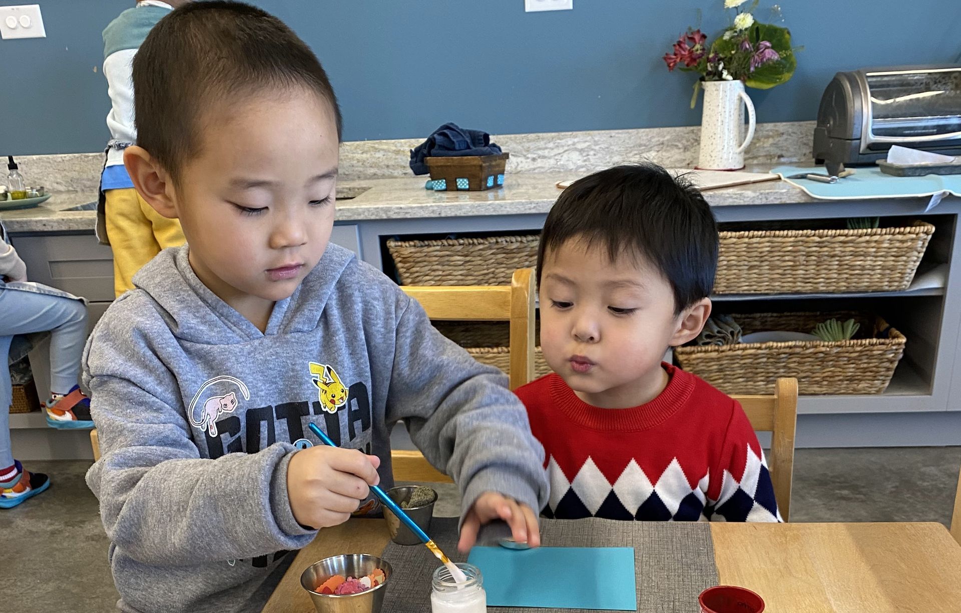 An older IMA student helps a younger friend. 