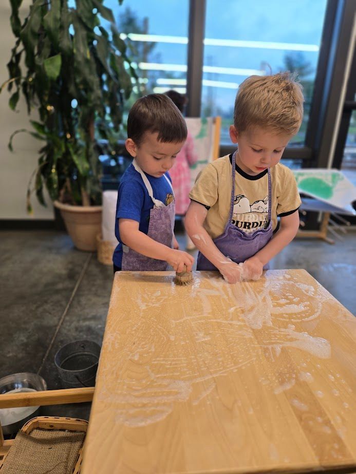 Two IMA students work together on Table Scrubbing. 